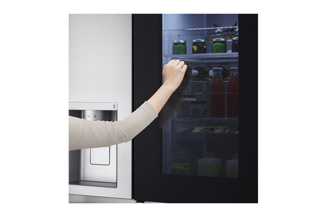 LG GC-X257CSEW 668L Side-By-Side Refrigerator with Water Dispenser, Knock Twice, Silver 4 A hand knocking on the black glass panel, which has lit up to reveal jars and bottles on the shelves inside