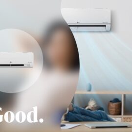 The white LG indoor unit fitted high on a living room wall, blowing air across a woman relaxing on a sofa
