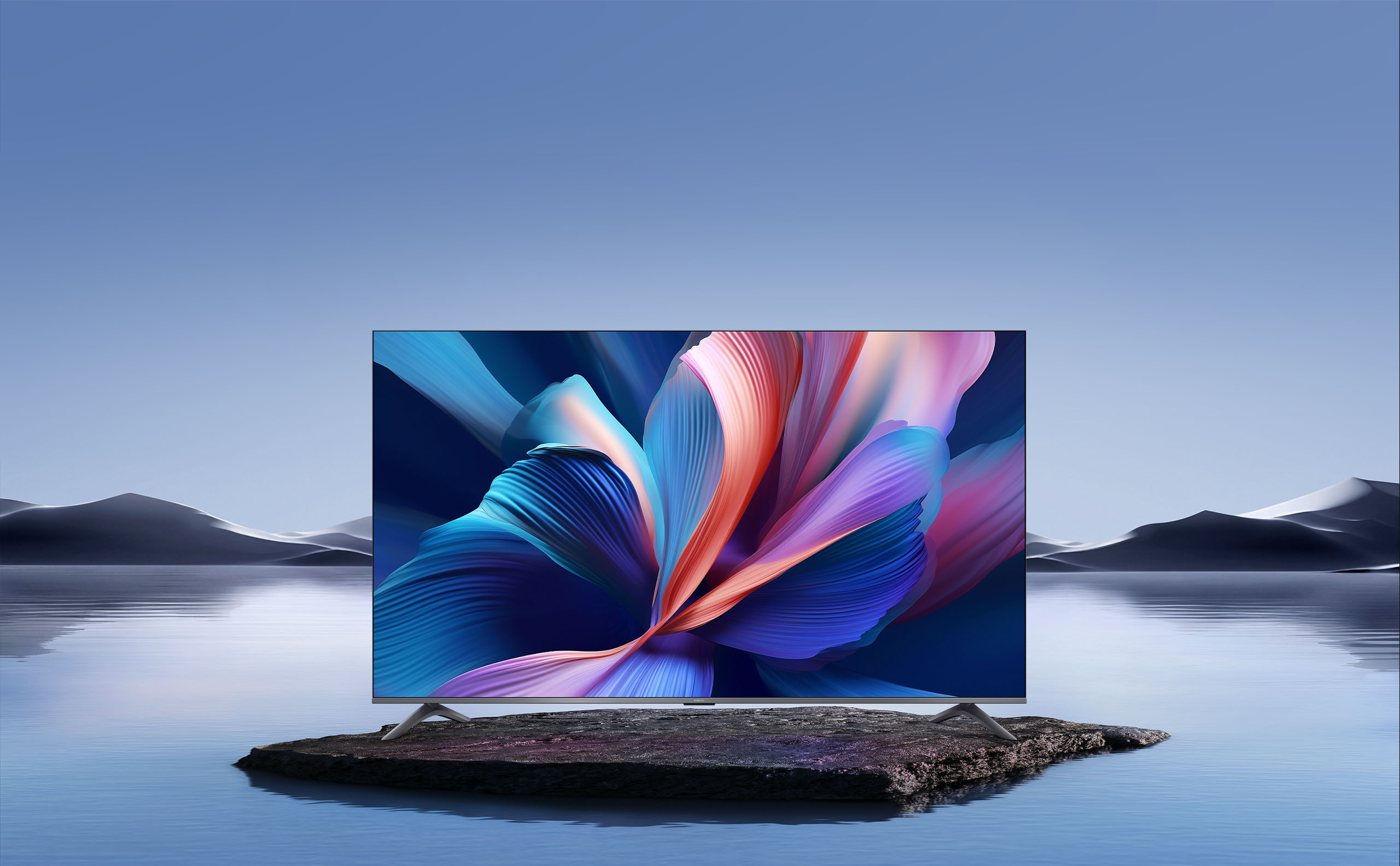 The Xiaomi TV A Pro 65 2026 standing on a rock by calm water